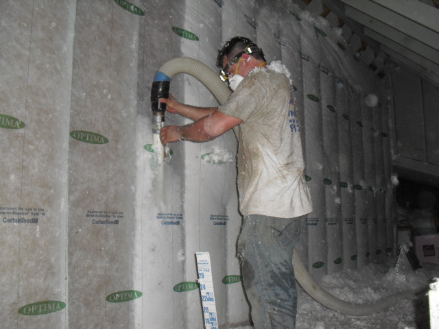 A man putting insulation in a home